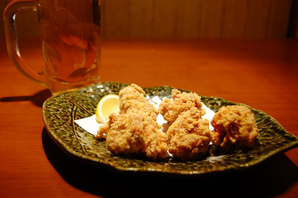 居酒屋のテーブルに並ぶ唐揚げとお酒